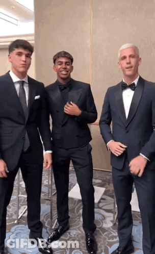 Three Men In Tuxedos Pose For Picture GIF