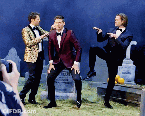 Three Men In Tuxedos Posing At Smith Gravestone GIF