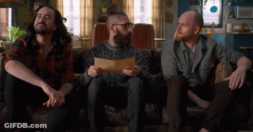 Three Men On Couch One Holding Paper GIF