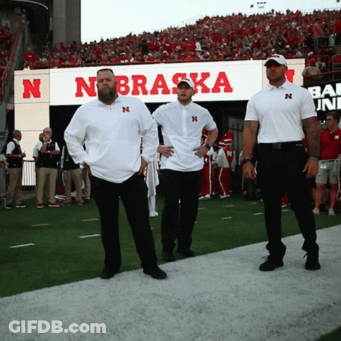Three Men On Football Field In Front Of Nebraska Sign GIF