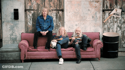 Three Men On Pink Couch In Front Of Building With No Parking Sign GIF