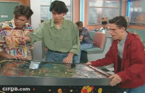 Three Men Playing Pinball Machine In Diner With TNT Sign GIF