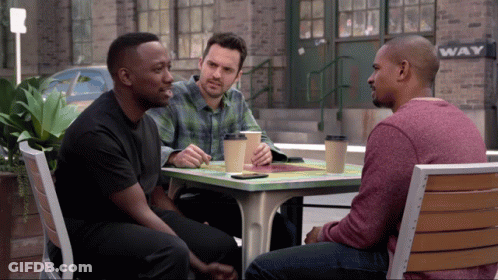 Three Men Sitting At Table In Front Of Wave Sign GIF