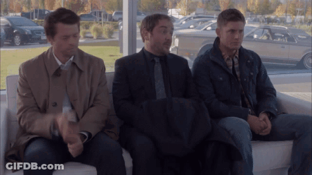Three Men Sitting On Couch In Front Of Window With Cars GIF