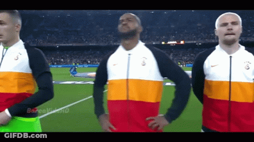 Three Men Stand On A Soccer Field Wearing Nike Jackets With The Letters G On Them GIF