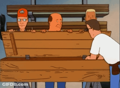 Three Men Standing Around Wooden Box With Skull Hat GIF