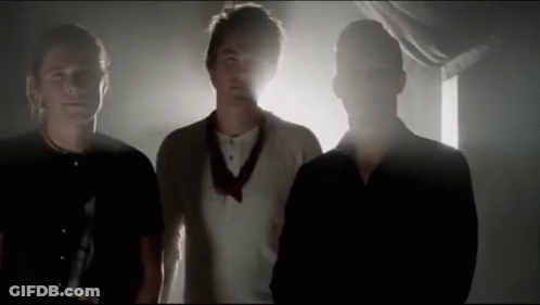 Three Men Standing In Dark Room GIF