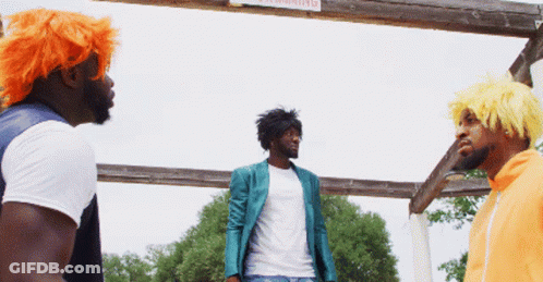 Three Men Standing In Front Of A Wooden Sign That Says Warning GIF