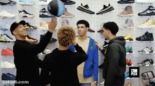 Three Men Standing In Front Of Wall Of Shoes Complex Sign GIF