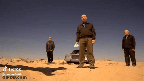 Three Men Standing In Sand In Front Of Car In Desert GIF