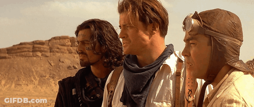 Three Men Standing Next To Each Other In The Desert GIF