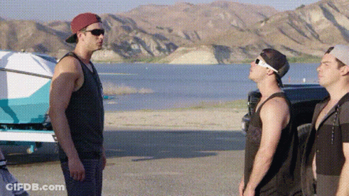 Three Men Standing Next To Each Other On A Beach Near A Lake . GIF