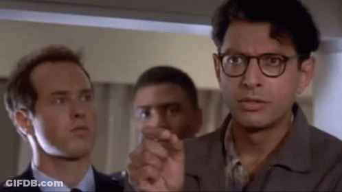 Three Men Standing, One Pointing At Camera GIF