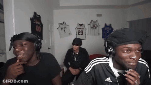 Three Men Wearing Headphones Are Sitting In A Room With Jerseys Hanging On The Wall Including One With The Number 23 On GIF