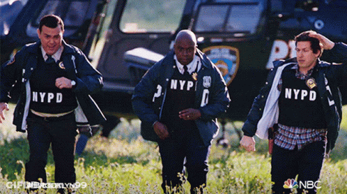 Three NYPD Officers Walking In Field With Helicopter GIF