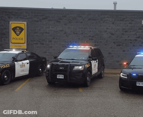 Three O.P.P. Police Cars Parked At Brick Building GIF
