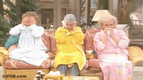 Three Older Women Are Sitting On A Couch Blowing Their Noses With Tissues . GIF