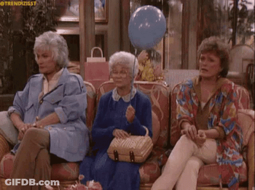 Three Older Women Are Sitting On A Couch With A Blue Balloon GIF