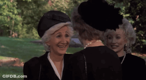 Three Older Women In Black Hats And Pearls Smiling GIF