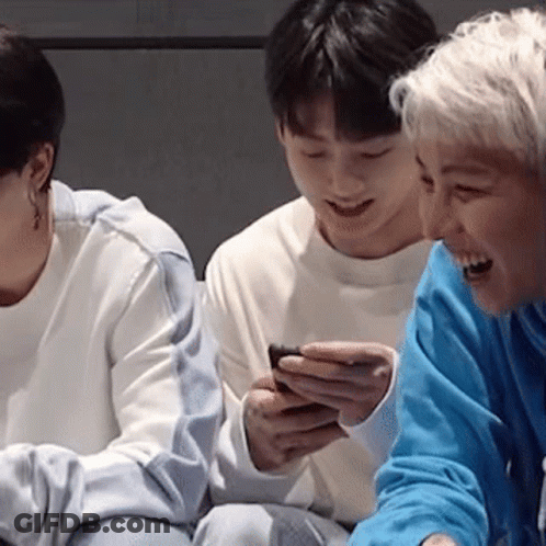 Three People Are Sitting Next To Each Other And One Of Them Is Holding A Cell Phone . GIF