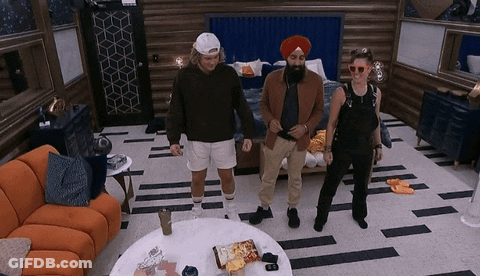 Three People Are Standing In A Room With A Couch And A Table GIF