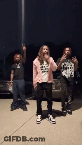 Three People Are Standing In Front Of A Car And One Of Them Has A Shirt That Says " I 'M A Rapper " GIF
