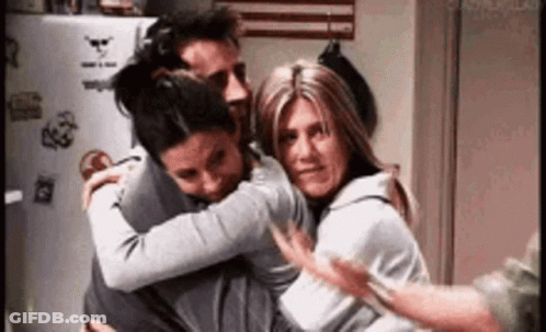 Three People Hugging In Kitchen GIF