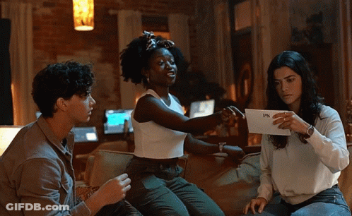 Three People On Couch Holding FPS Paper GIF