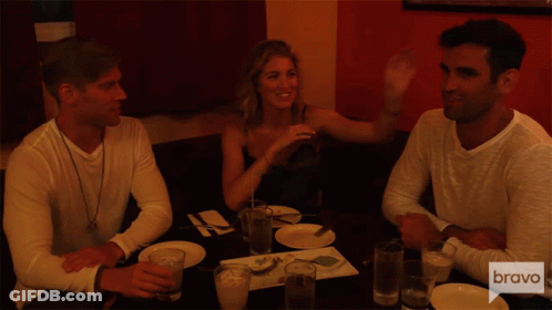 Three People Sitting At Table With Bravo GIF