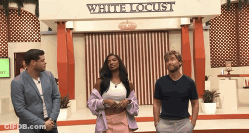 Three People Standing In Front Of White Locust Sign GIF