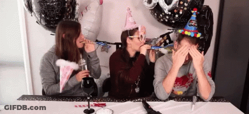 Three People Wearing Party Hats Blowing Party Horns GIF