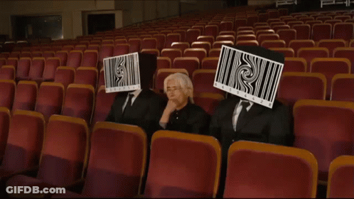 Three People With Barcodes On Face In Auditorium GIF