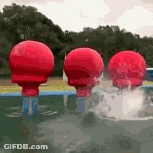 Three Red Balls Are Floating In A Pool . GIF