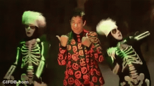 Three Skeletons Are Dancing In Front Of A Man In A Red Suit GIF