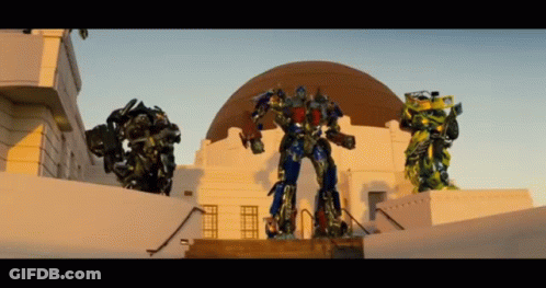 Three Transformers Standing In Front Of Dome GIF