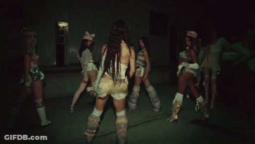 Three Women Are Dancing In A Dark Room With One Wearing A Pink Cat Hat GIF