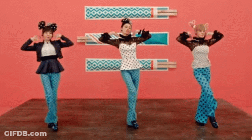 Three Women Are Dancing In Front Of A Pink Background GIF