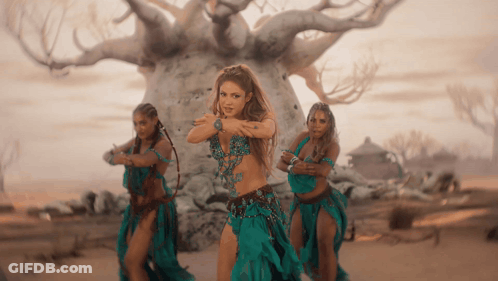 Three Women Are Dancing In Front Of A Tree GIF