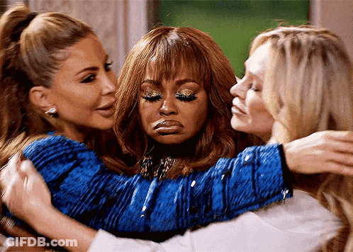 Three Women Are Hugging Each Other And One Of Them Is Wearing A Blue Top . GIF