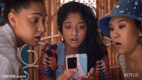 Three Women Are Looking At A Cell Phone With Netflix Written On The Bottom GIF