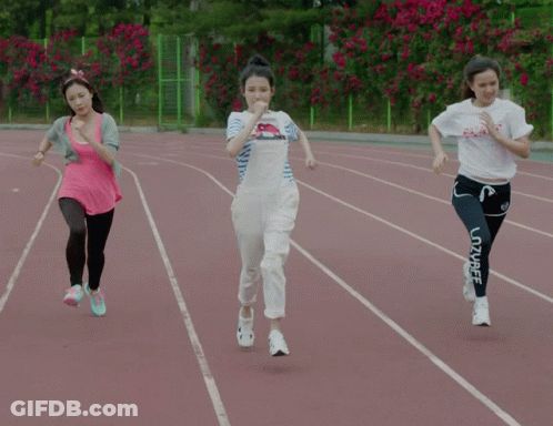 Three Women Are Running On A Track And One Of Them Is Wearing A White Shirt That Says Peace GIF