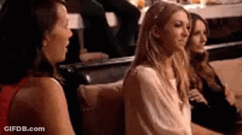 Three Women Are Sitting Next To Each Other On A Couch . GIF