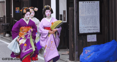 Three Women In Kimonos Walking Past Chinese Sign GIF