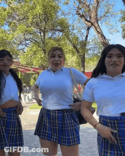 Three Women In School Uniforms Posing In Park GIF