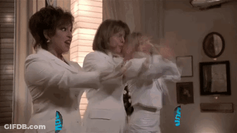 Three Women In White Suits Standing In Living Room GIF