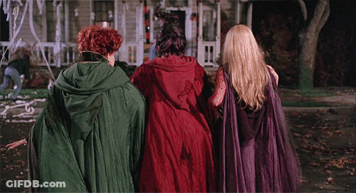 Three Women In Witch Costumes Walking Down Street GIF