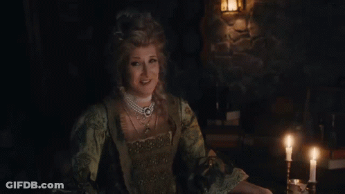 Three Women Laughing At Table In Dark Room GIF