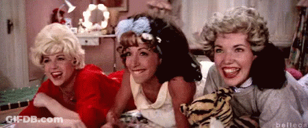 Three Women Lying On Bed With Stuffed Tiger GIF