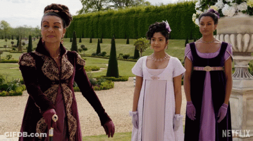 Three Women Standing In A Garden With A Netflix Logo On The Bottom Left GIF