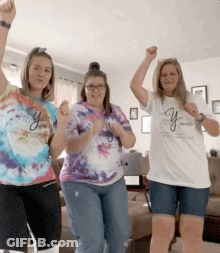 Three Women Wearing Tie Dye Shirts With The Word Young On Them Are Dancing In A Living Room GIF